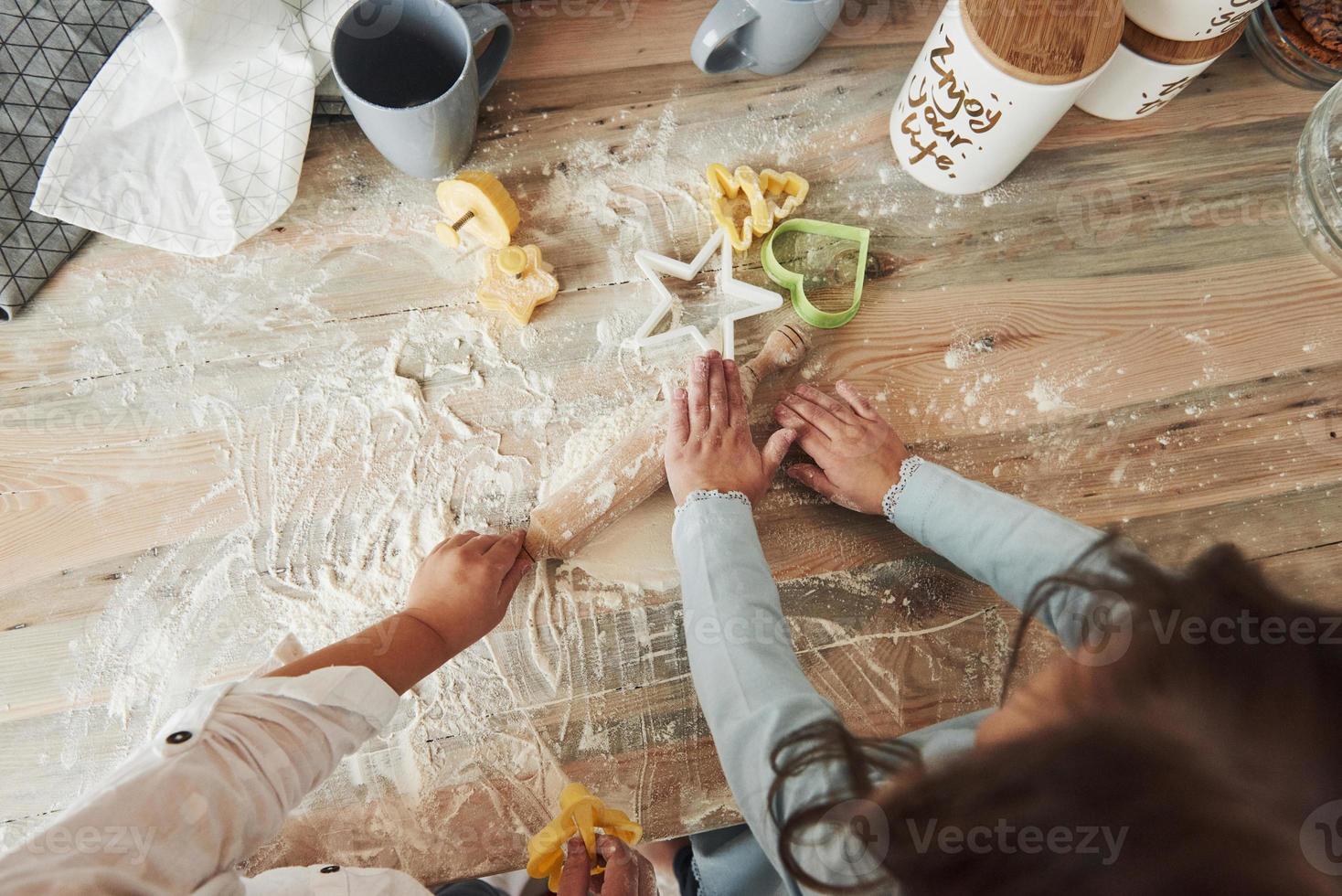 artículos con formas de colores. vista superior de los niños aprendiendo a preparar comida a partir de la harina con instrumentos formados especiales foto