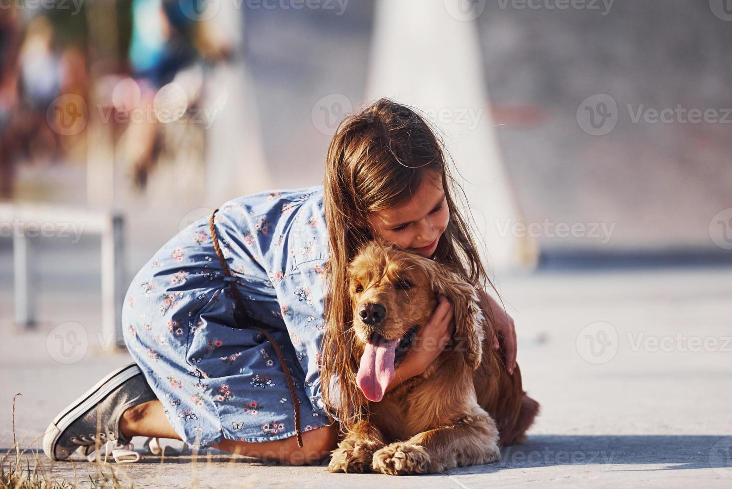 Embracing the pet. Cute little girl have a walk with her dog outdoors at sunny day photo