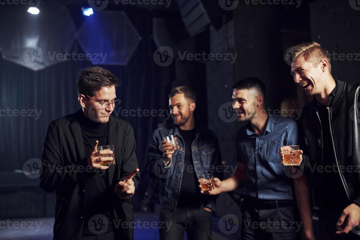 People have fun in the night club. With alcohol in hands photo