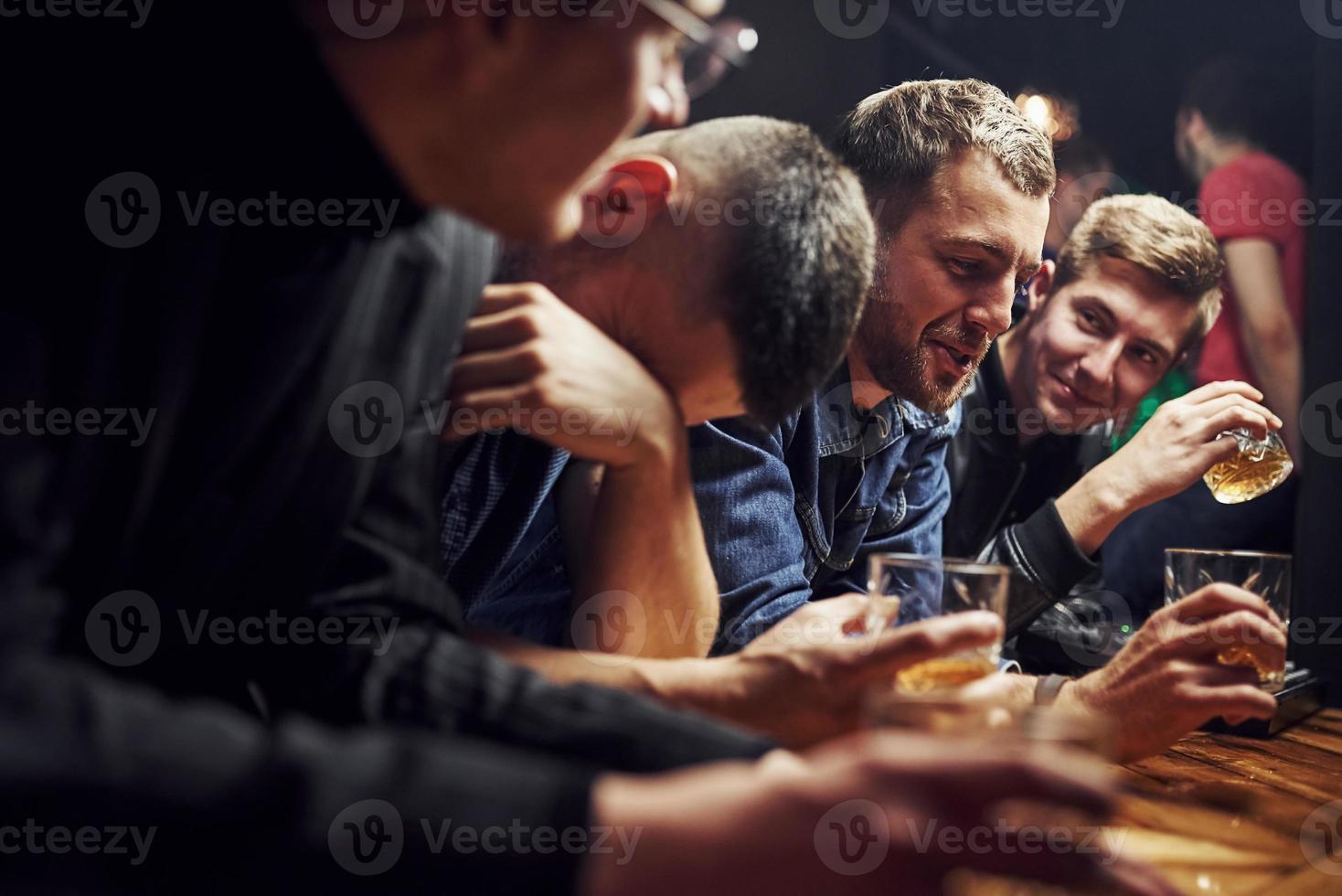 Guy feels awful. Friends resting in the pub with alcohol in hands. Having conversation photo