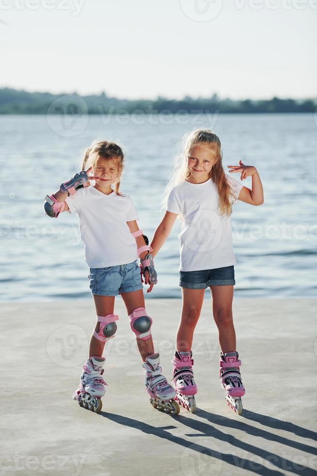 Posing for a camera. Happy female friends on roller skates. Leisure time photo