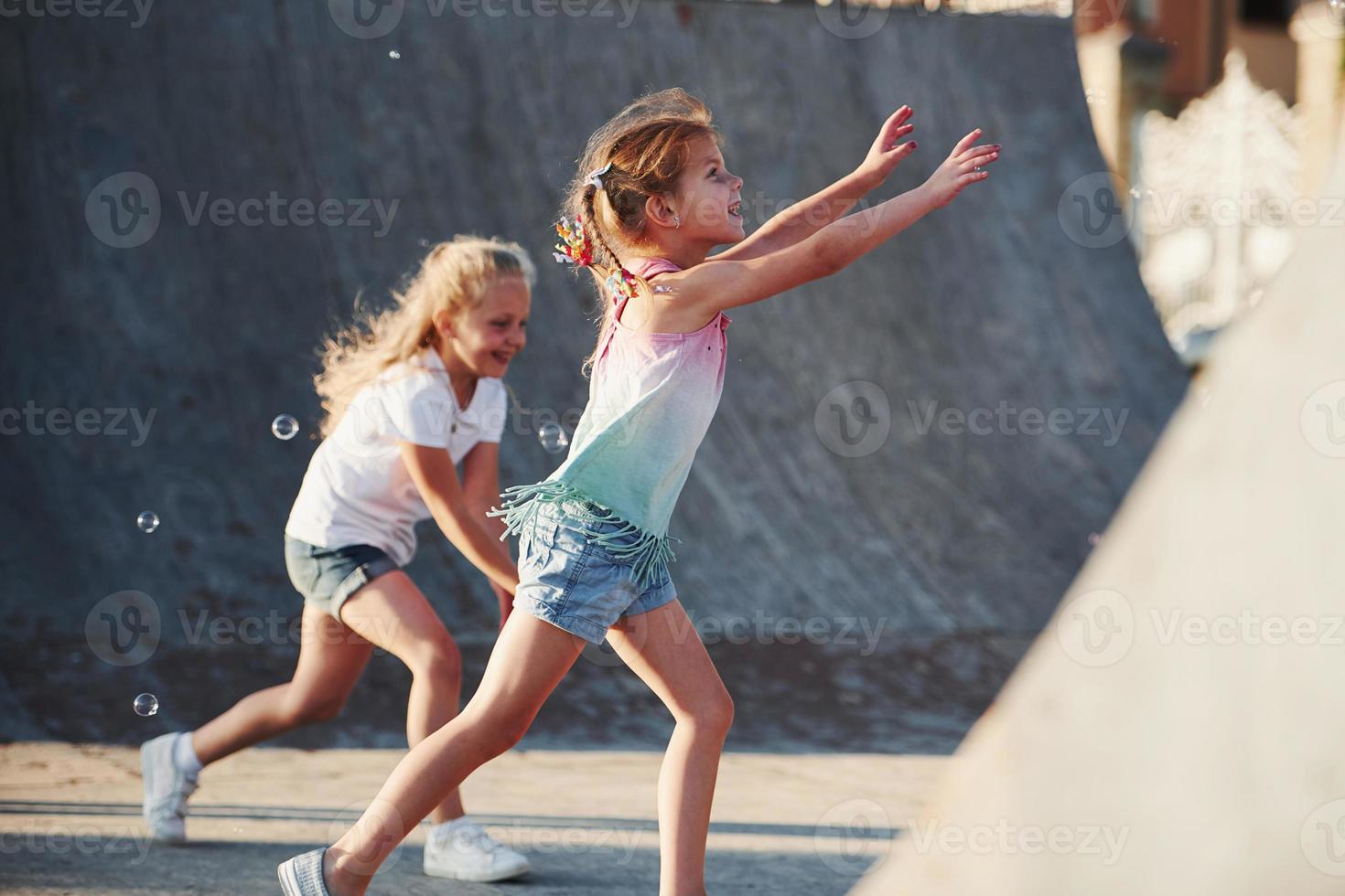 Having fun with bubbles. Leisure activities. Two little girls having fun in the park photo