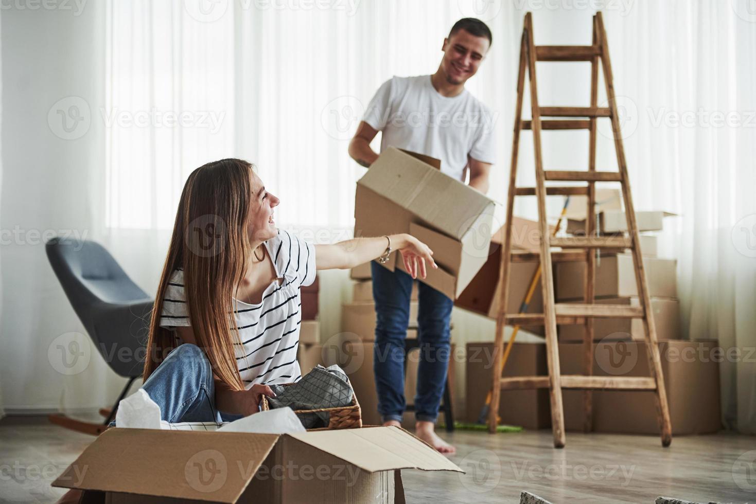 hora de desempacar esas cajas. pareja joven alegre en su nuevo apartamento. concepción de movimiento foto