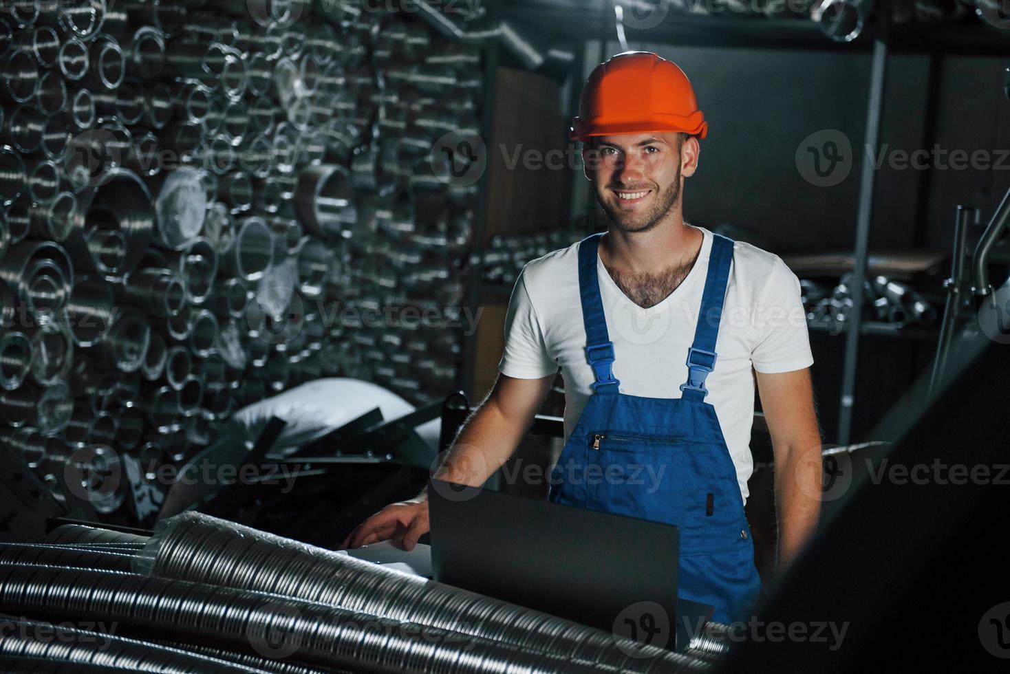 Positive mood. Man in uniform works on the production. Industrial modern technology photo