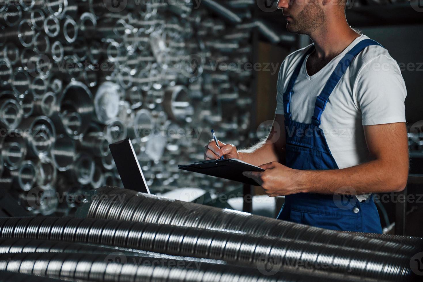 Counting objects. Man in uniform works on the production. Industrial modern technology photo