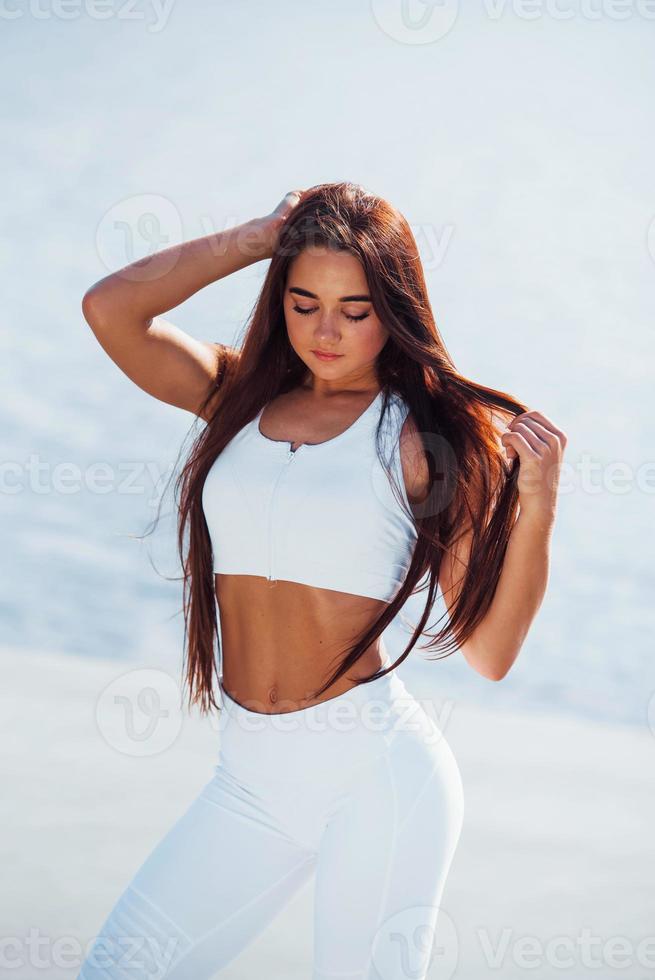 Posing for the camera. Young fitness woman with slim body type is outdoors photo