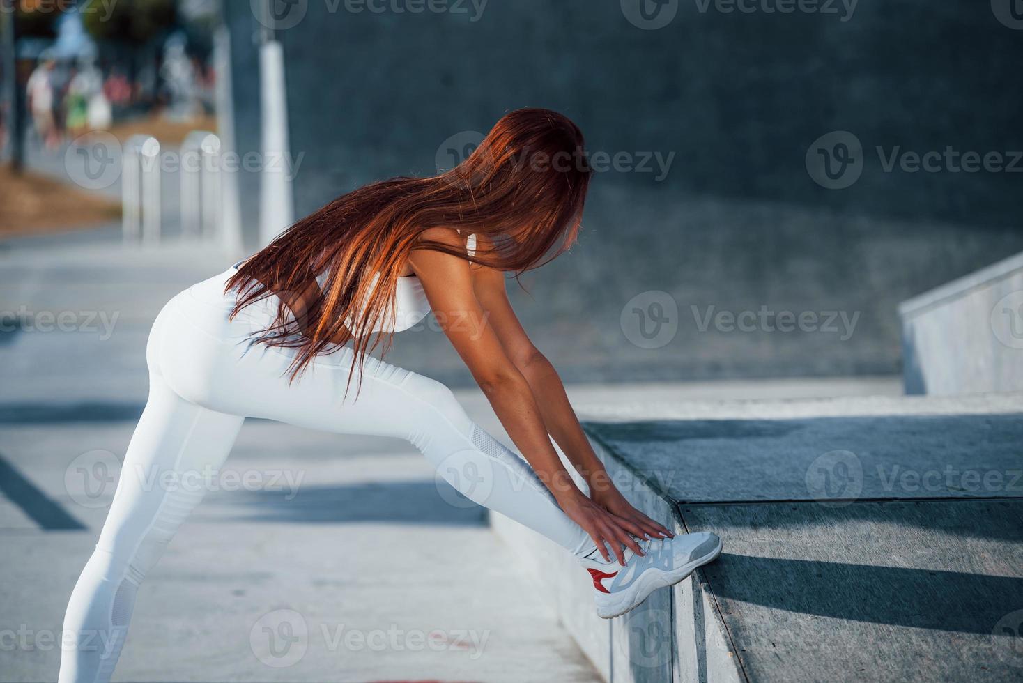 Fitness woman having a rest near the lake at daytime. Beautiful sunlight photo