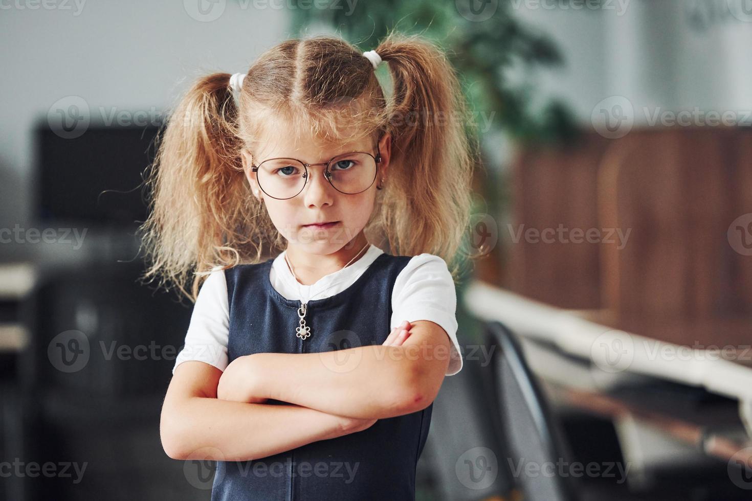 retrato de una niña ofendida que está adentro con los brazos cruzados foto
