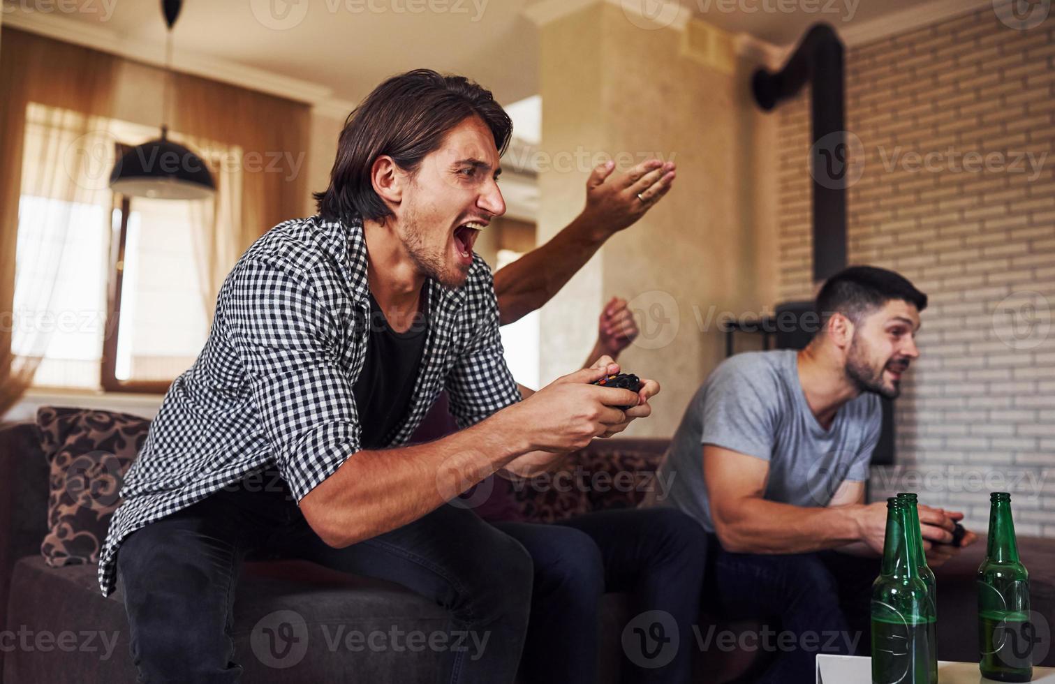 grupo de amigos se divierten jugando juegos de consola en el interior de la sala de estar foto