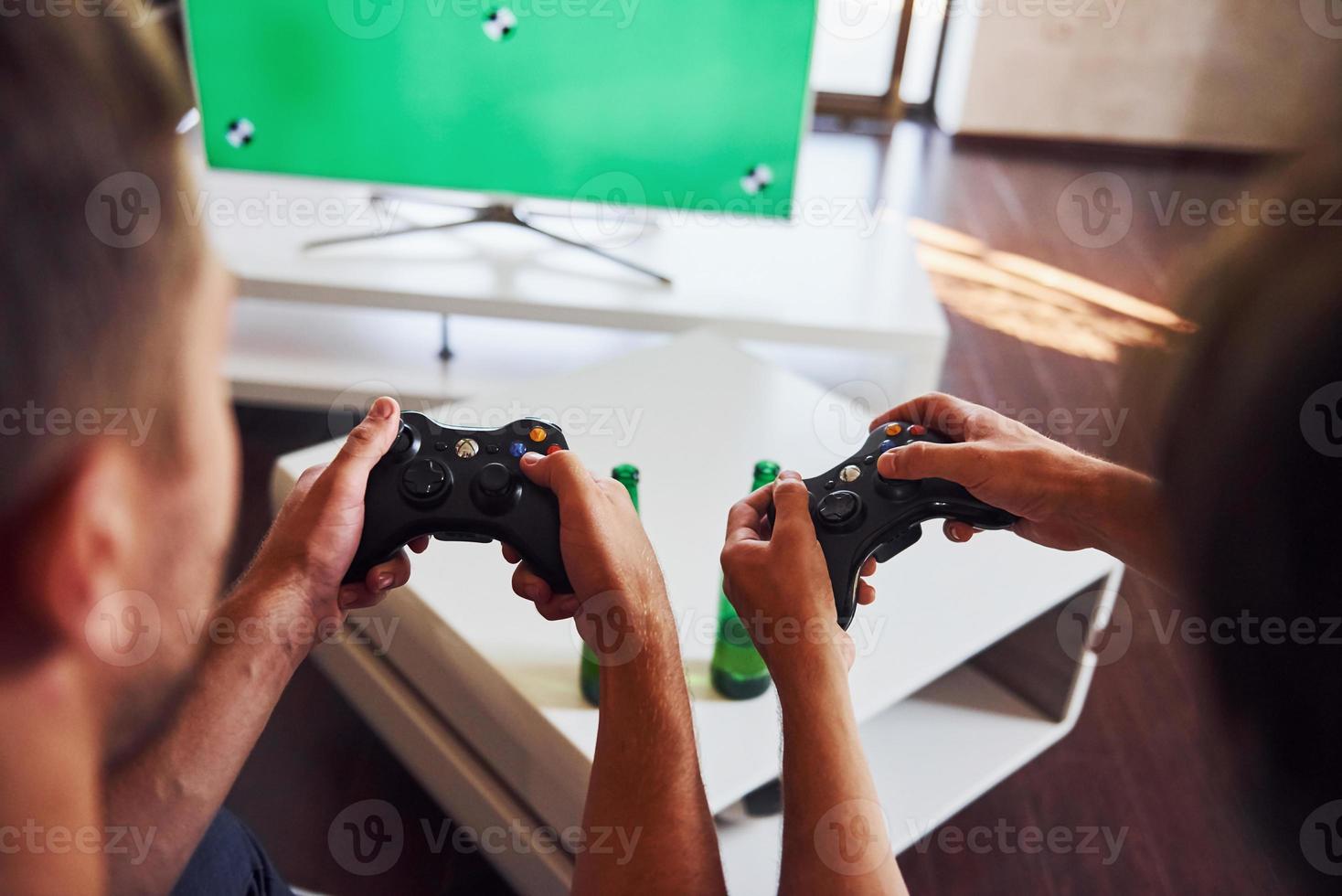 Group of friends have fun playing console game indoors at living room photo