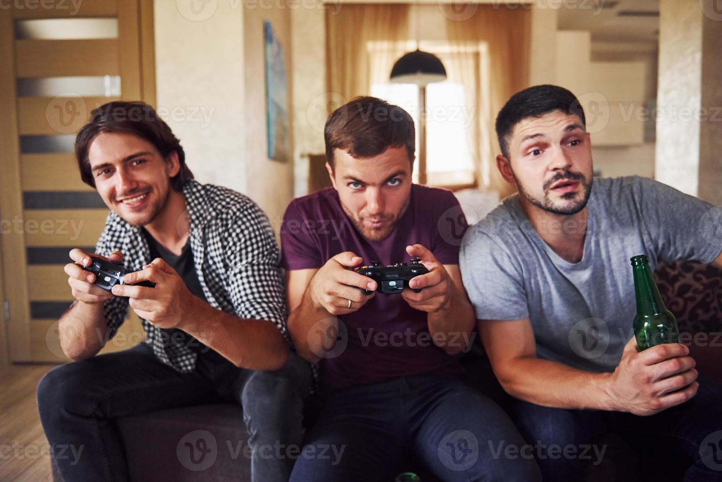 grupo de amigos se divierten jugando juegos de consola en el interior de la sala de estar foto