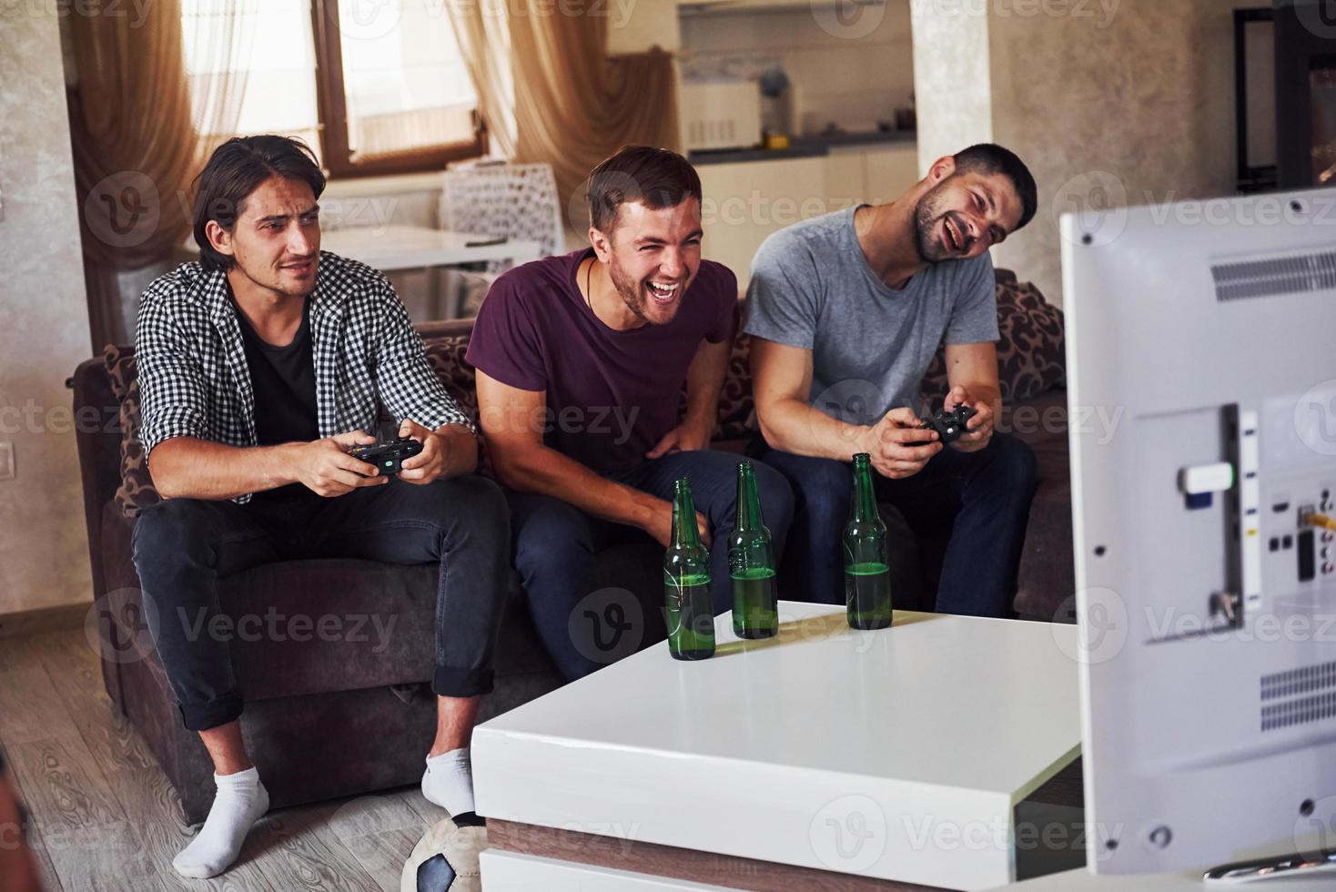 grupo de amigos se divierten jugando juegos de consola en el interior de la sala de estar foto