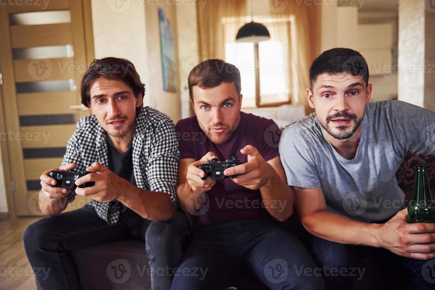 grupo de amigos se divierten jugando juegos de consola en el interior de la sala de estar foto