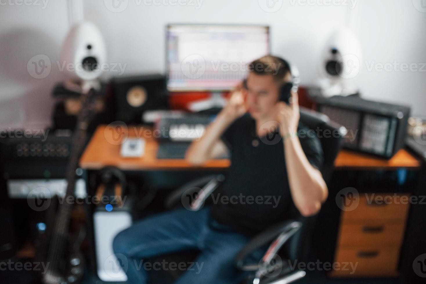 Sound engineer in headphones working and mixing music indoors in the studio photo