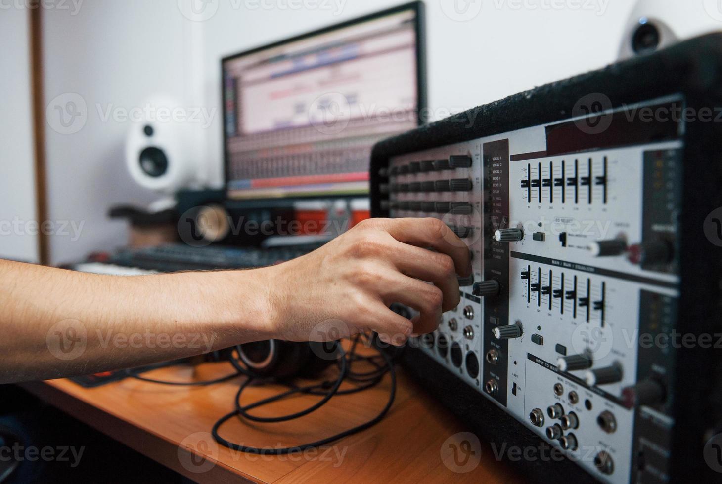 Using the mixer. Sound engineer working indoors in the studio photo