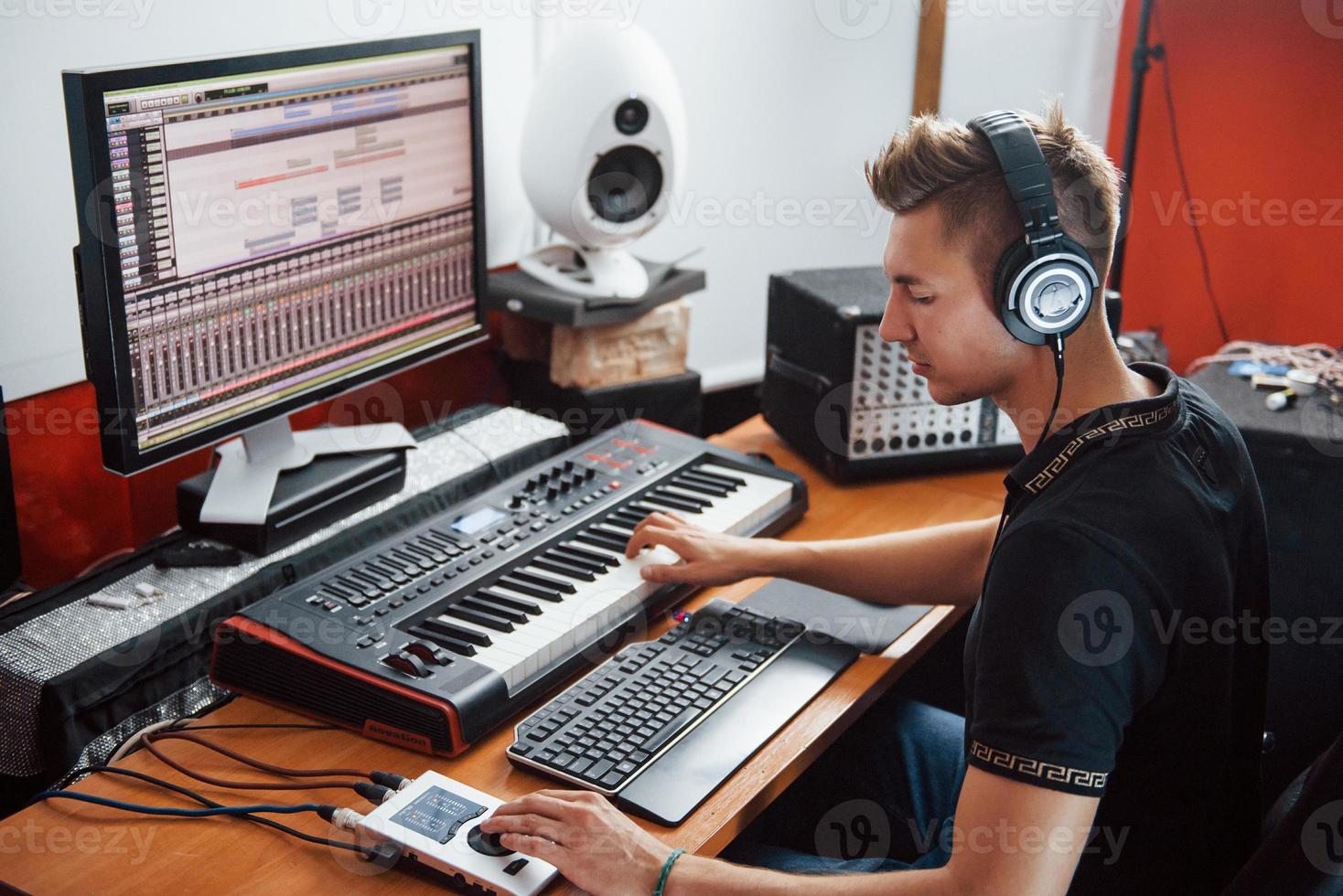 Sound engineer in headphones working and mixing music indoors in the studio photo