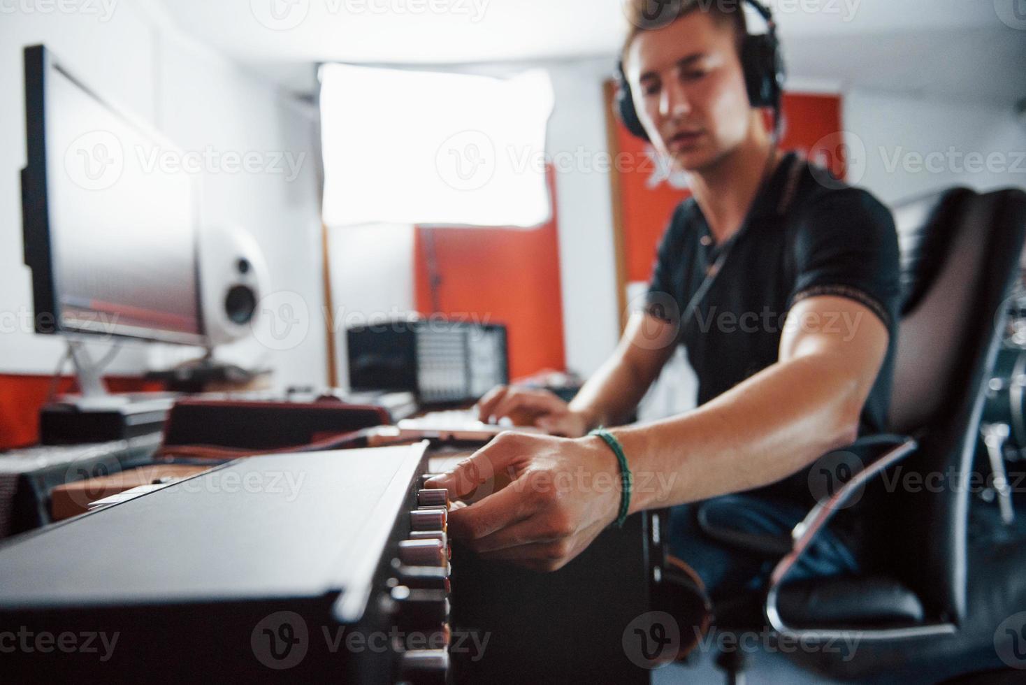 Sound engineer in headphones working and mixing music indoors in the studio photo
