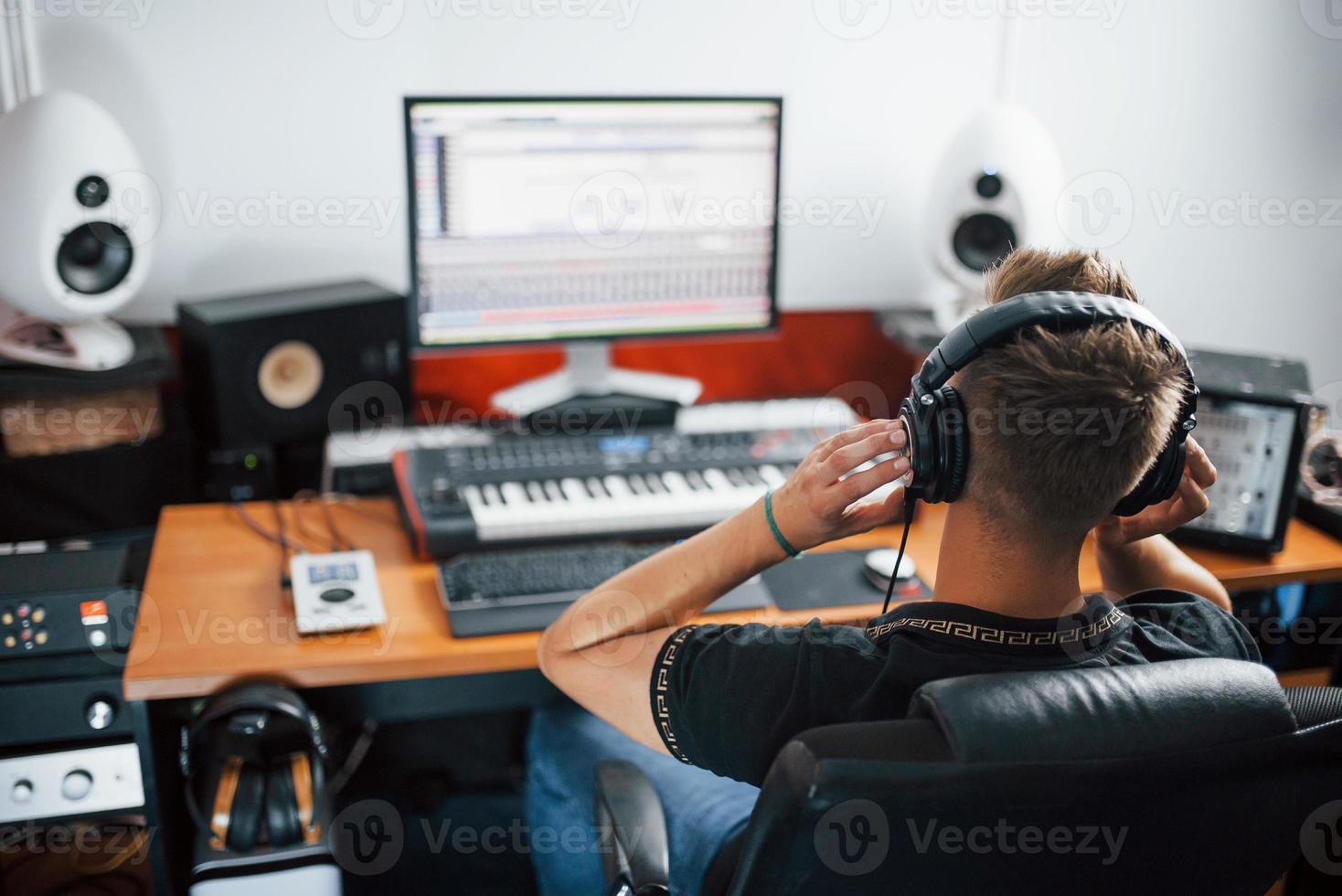 concentrado en el trabajo. ingeniero de sonido en auriculares trabajando y mezclando música en interiores en el estudio foto