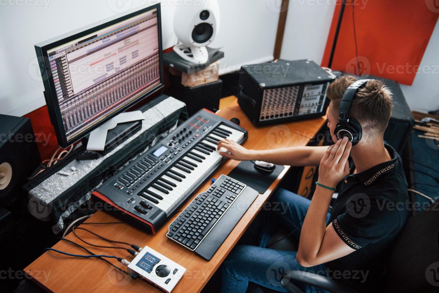 ingeniero de sonido en auriculares trabajando y mezclando música en interiores en el estudio foto