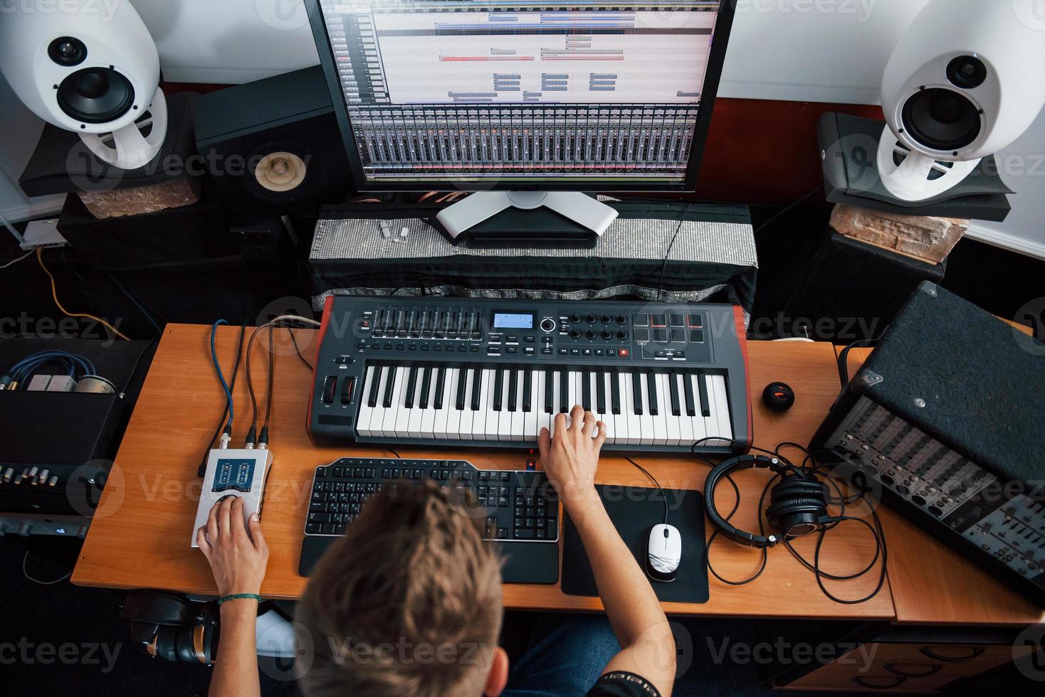 vista superior. ingeniero de sonido trabajando y mezclando música en interiores en el estudio foto