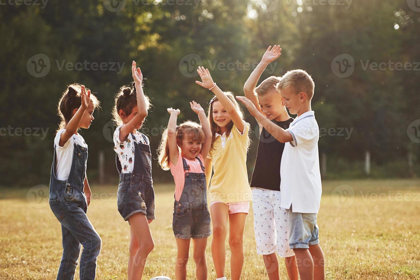 Ready for the game. Young sportive kids stands together in the field at sunny day photo