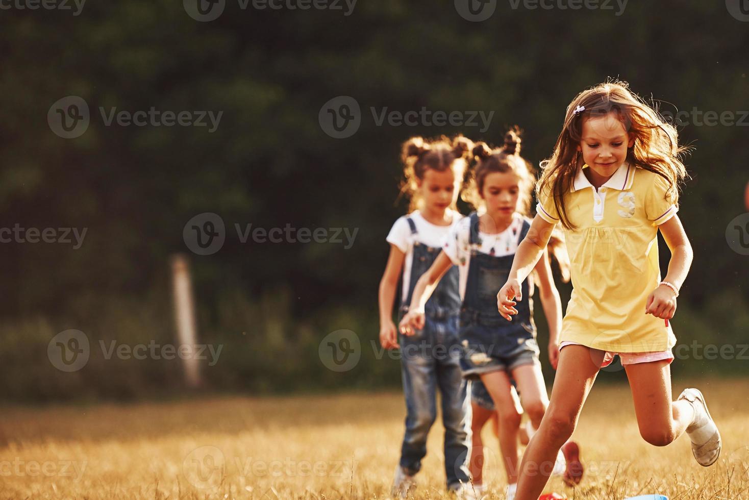 Through obstacles. Kids running in the field at sunny day. Conception of healthy lifestyle photo