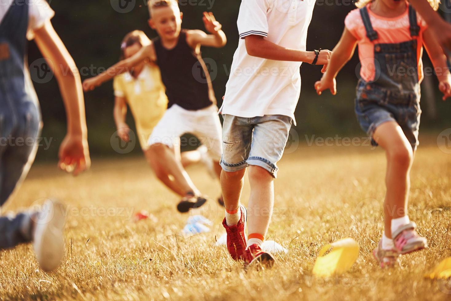 a través de obstáculos. niños corriendo en el campo en un día soleado. concepto de estilo de vida saludable foto