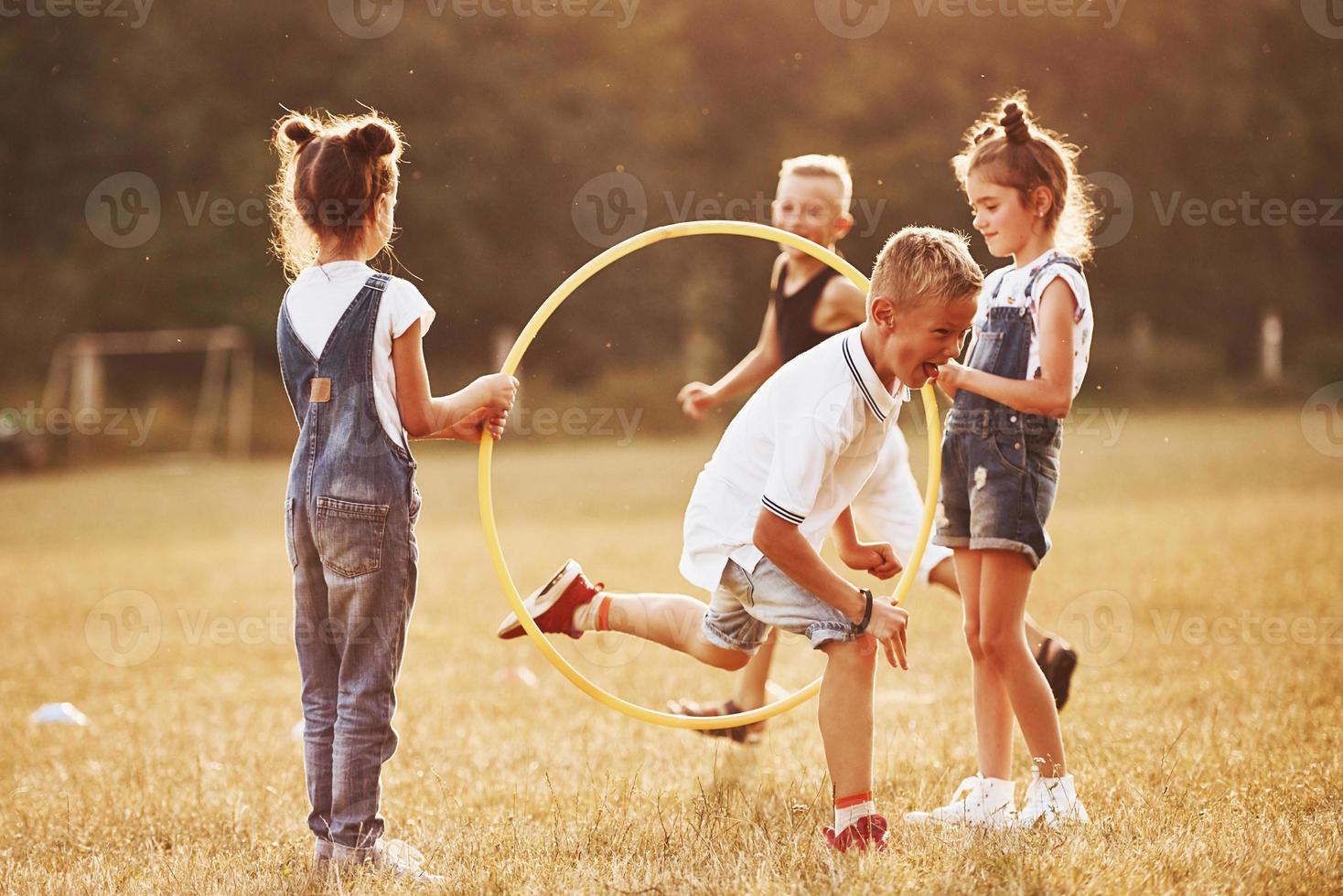 saltando a través de la herramienta de fitness circular. niños divirtiéndose en el campo foto