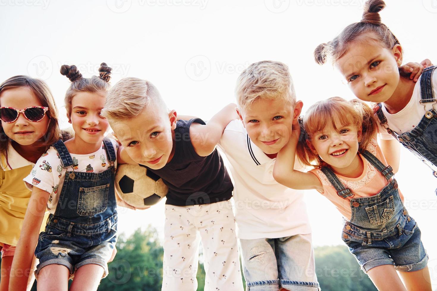 With soccer ball. Portrait of kids that standing together and posing for the camera photo