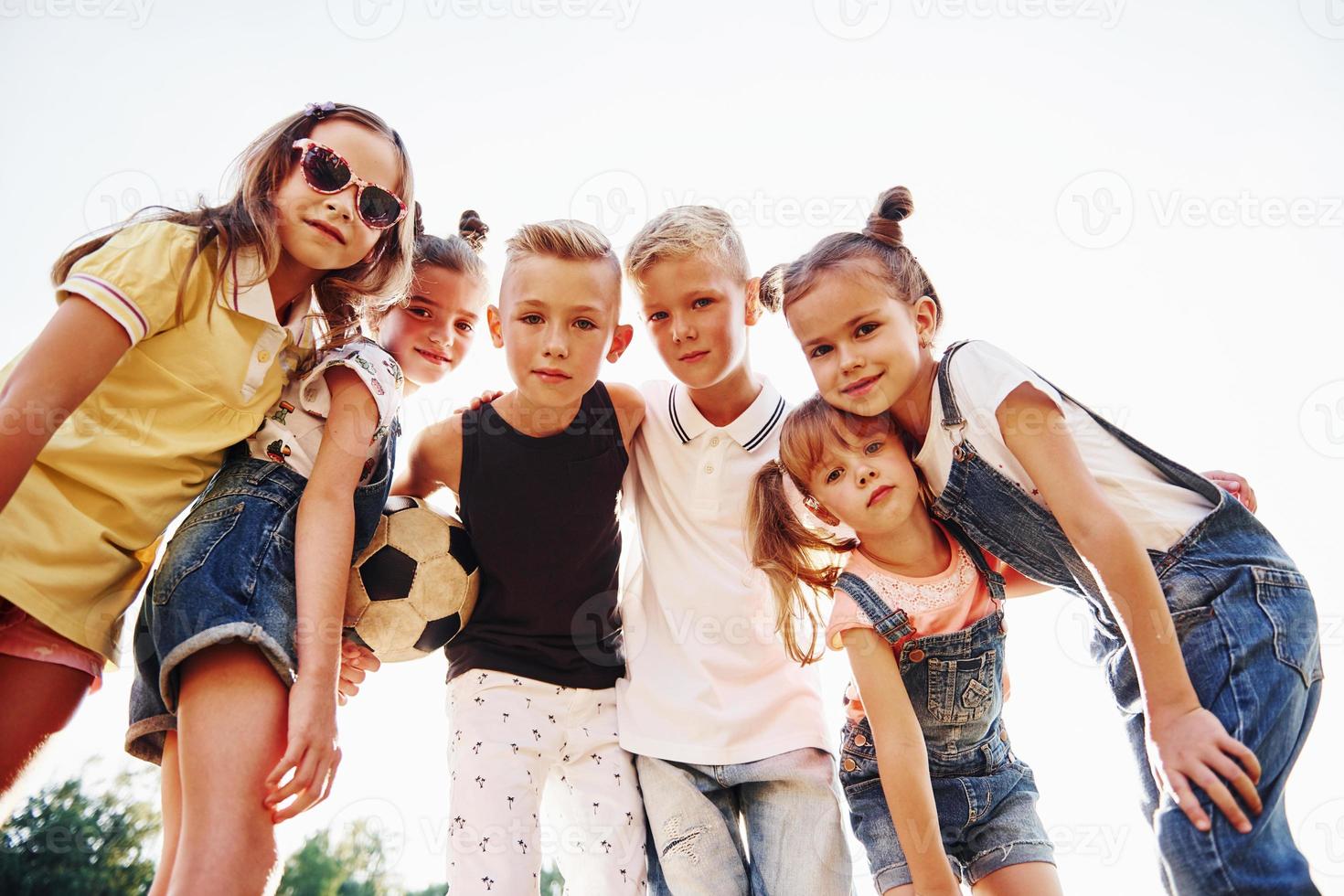 With soccer ball. Portrait of kids that standing together and posing for the camera photo