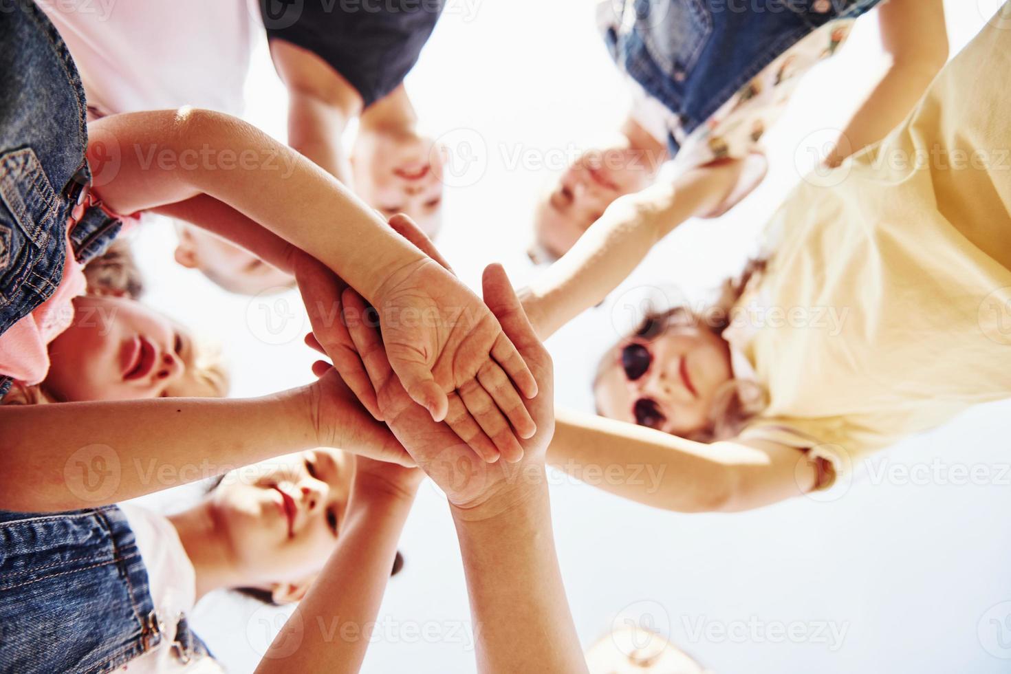 Hands crossed. Portrait of kids that standing together and posing for the camera photo