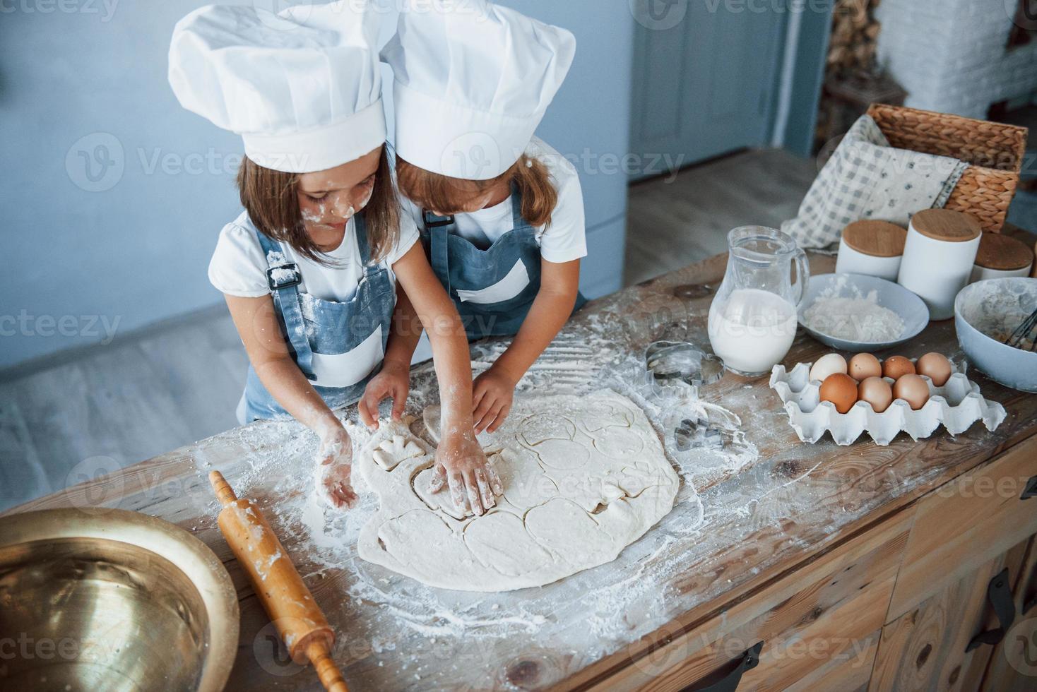 concentrarse en la cocina. niños de familia con uniforme de chef blanco preparando comida en la cocina foto