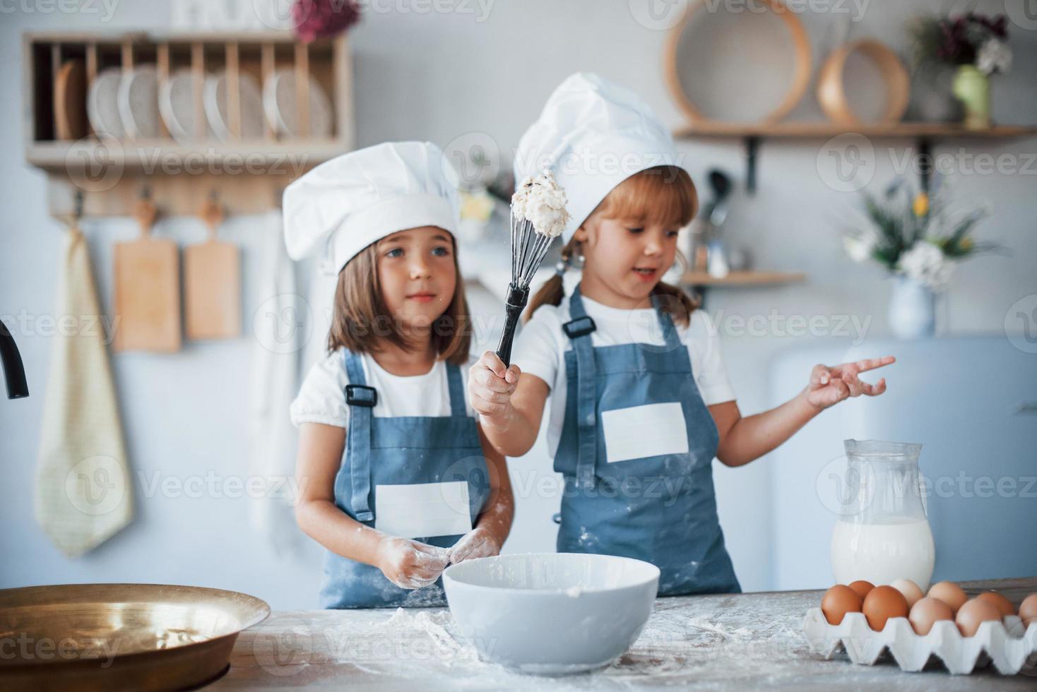 Family kids in white chef uniform preparing food on the kitchen photo