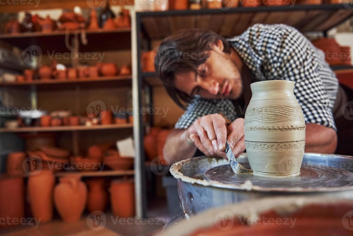 Detailing by special tool. Ceramist uses potter's wheel and creates a