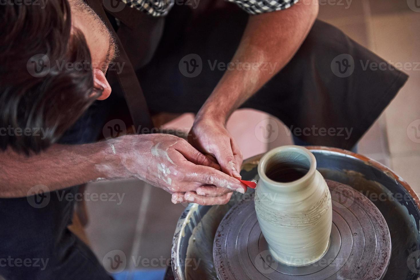 Makes lines with tool. Ceramist uses potter's wheel and creates a