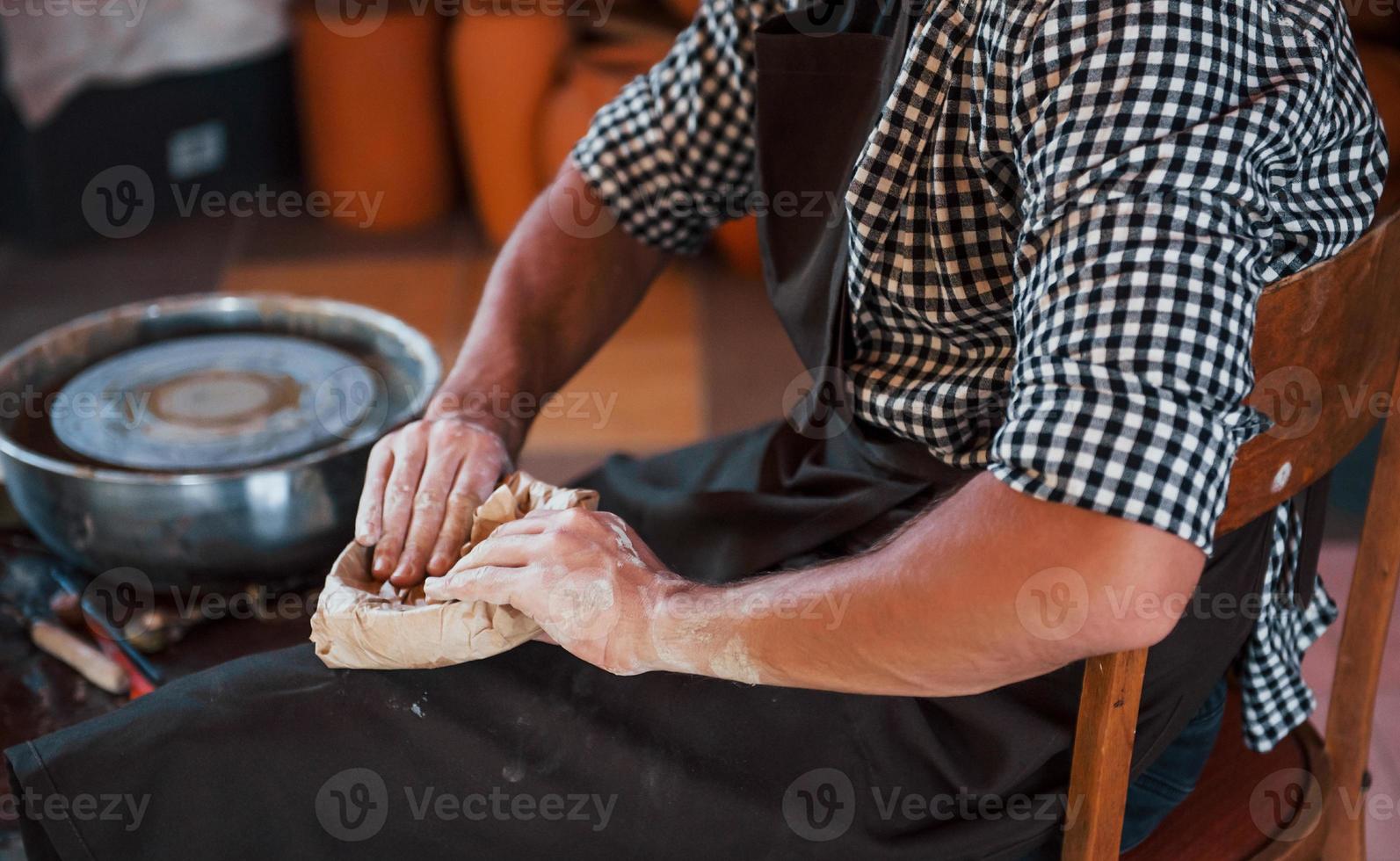 Close up photo of ceramist packages his fresh product in the paper