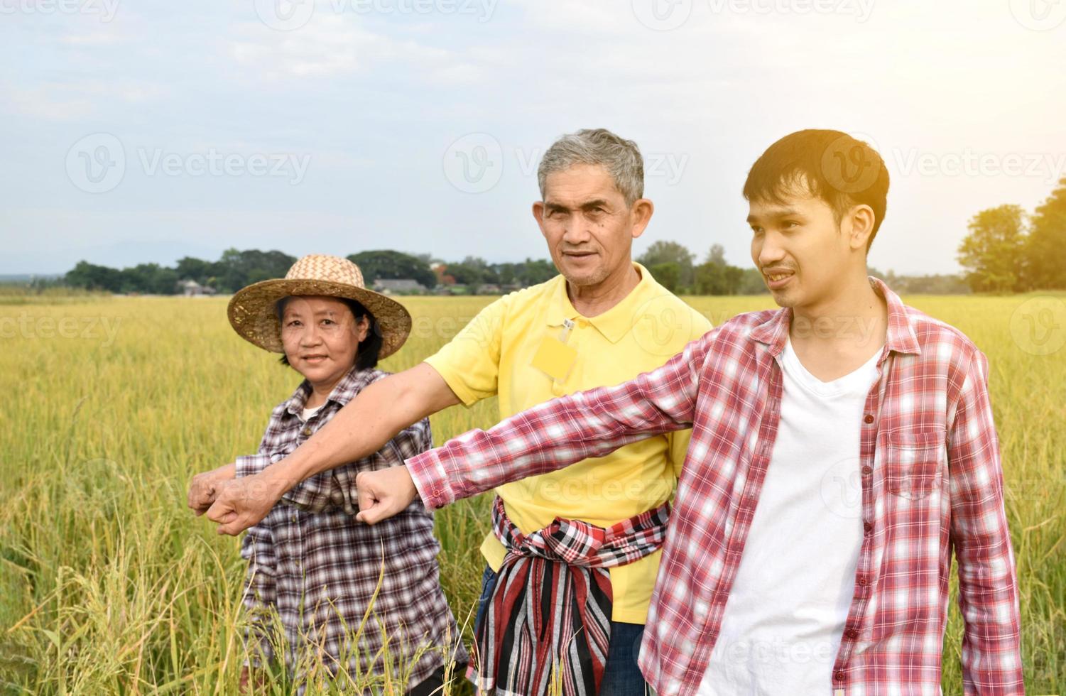 Portrait asian elderly man in yellow shirt is taking note planting information by asking and interviewing young asian man and female farmer nearby, soft and selective focus. photo