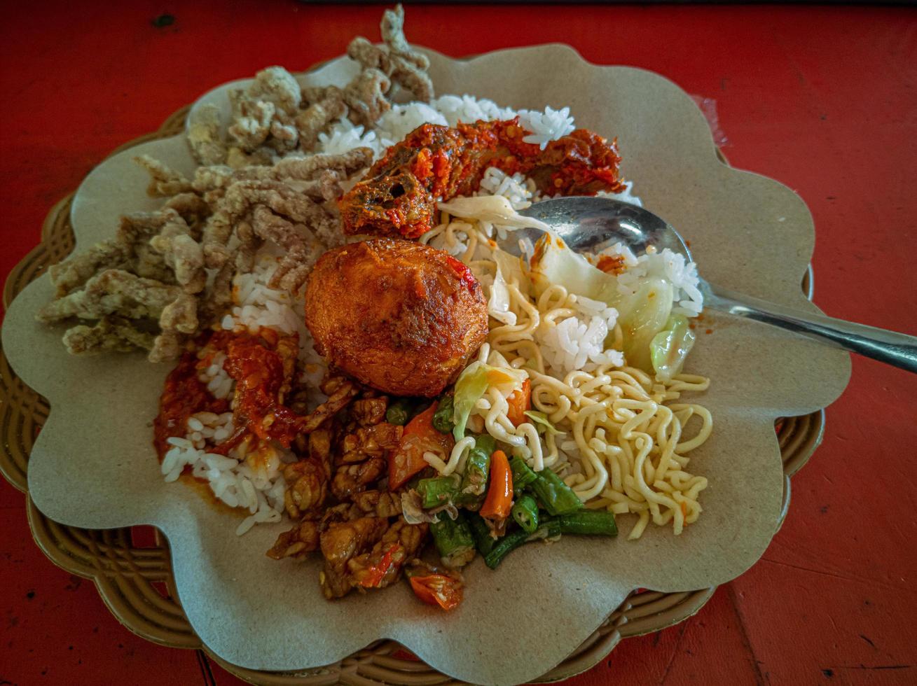 arroz mezclado. una popular comida de arroz de especialidad indonesia con varias guarniciones servidas con arroz y otras adiciones opcionales. foto