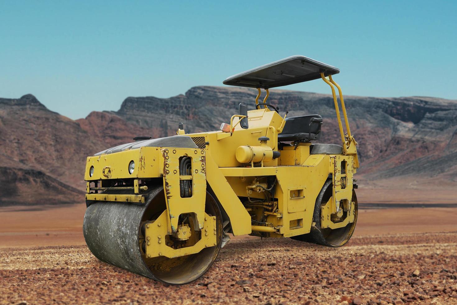 Rodillo de camino, una máquina de suavizado de caminos de asfalto amarillo en un pequeño pueblo foto