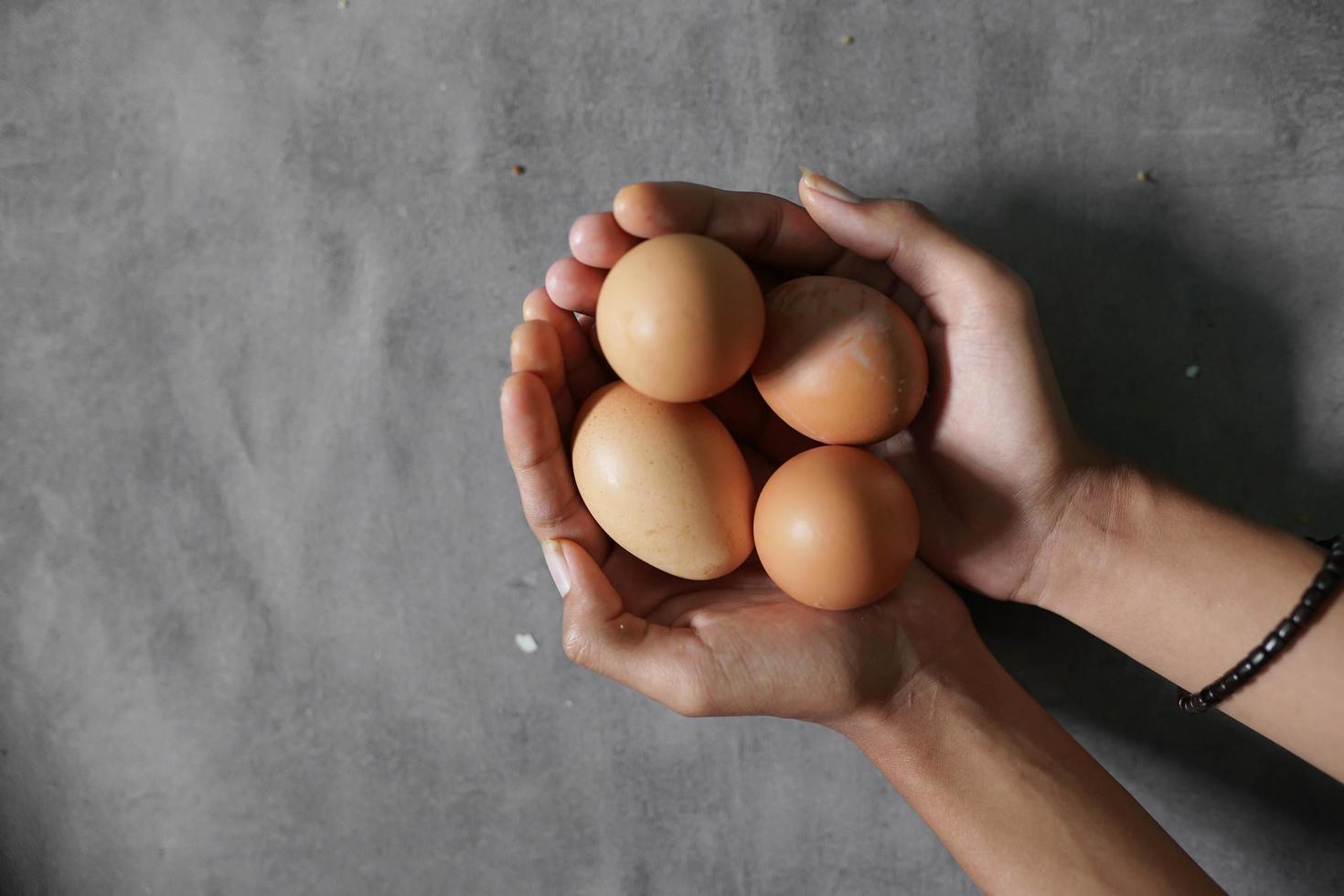 a bunch of eggs on a hand on a concrete background photo
