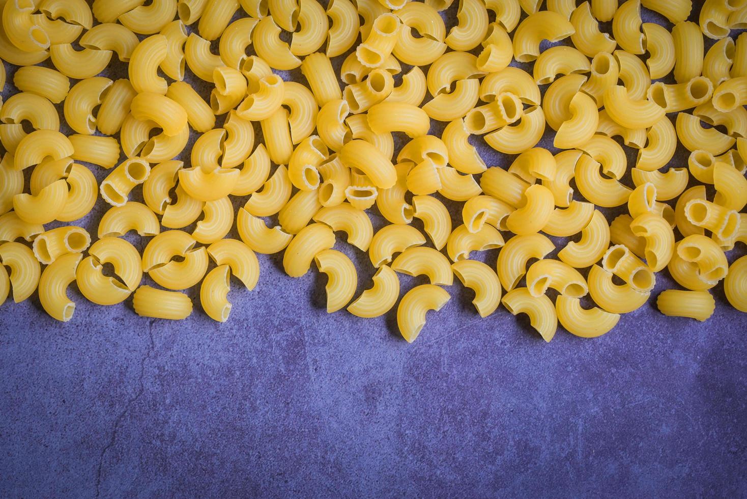 Pasta background - top view, raw macaroni texture background, close up raw macaroni pasta uncooked delicious pasta for cooking food photo