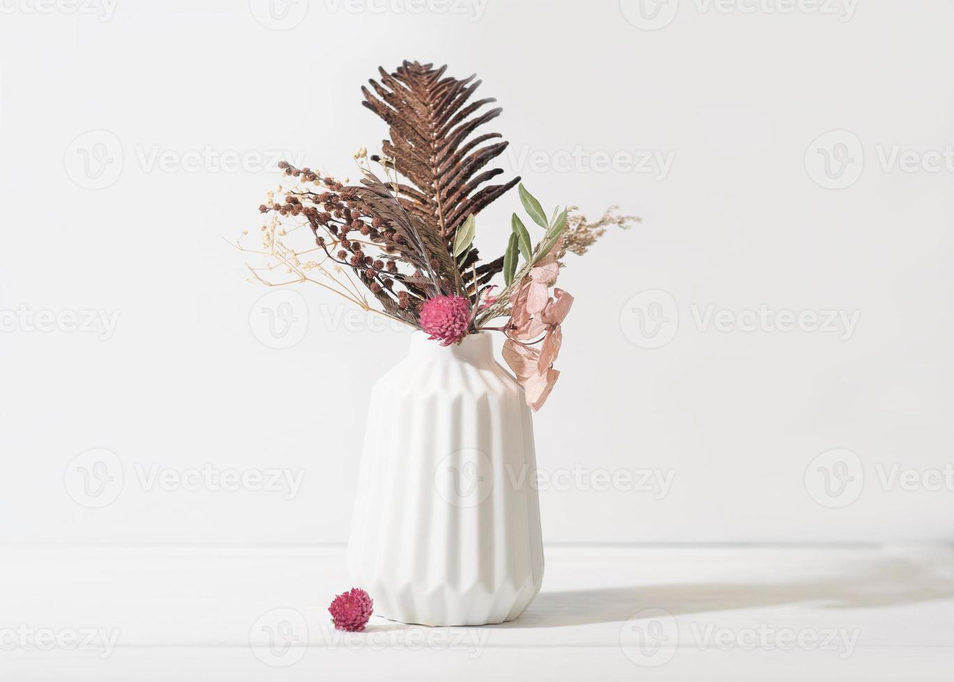 composición de ikebana estacional de otoño e invierno en jarrón blanco. flores secas y hojas como decoración del hogar. detalles de diseño de decoración de casa acogedora. foto