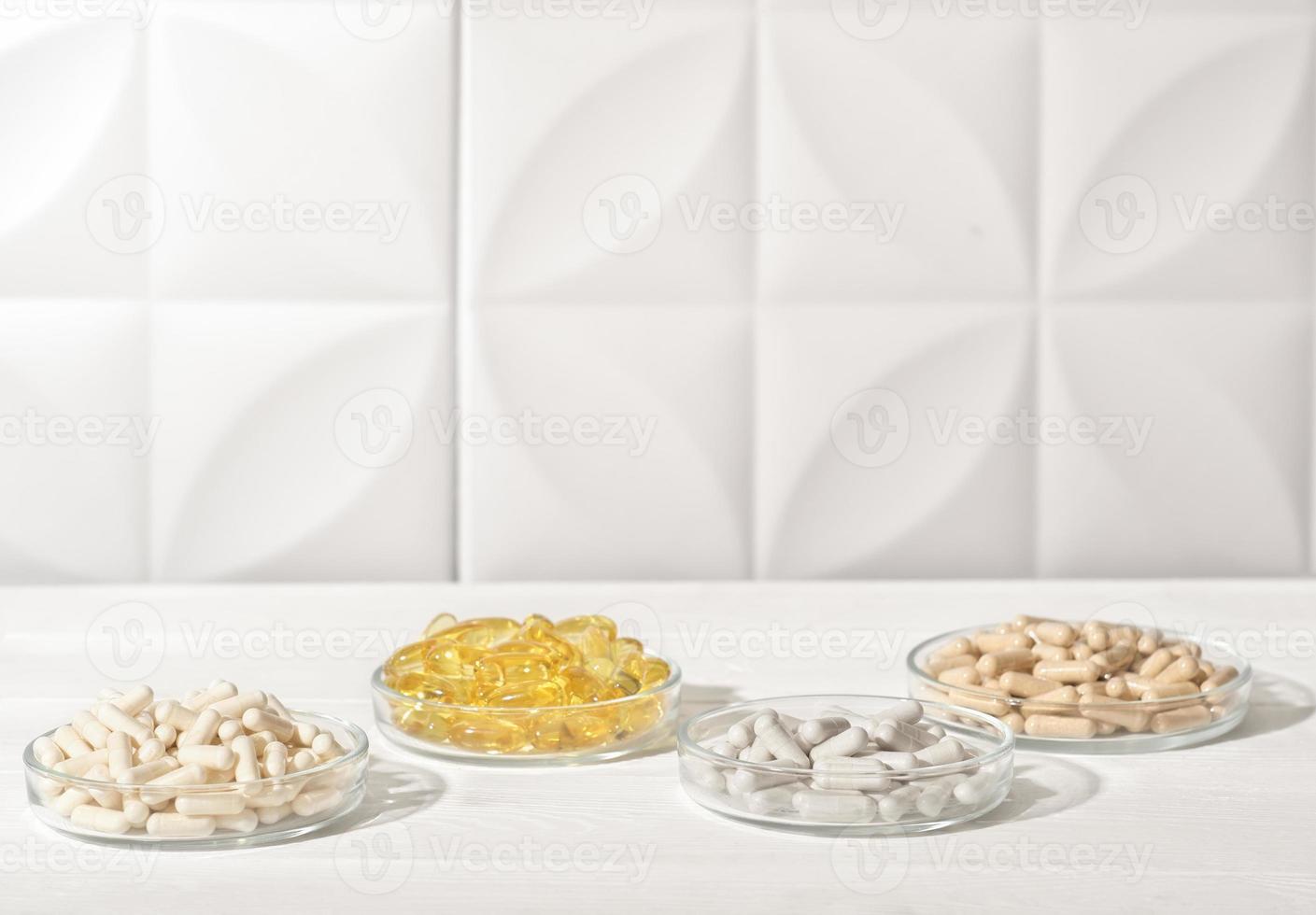 Nutrition supplements, various vitamins, vitamin C, magnesium, collagen peptides in capsules in petri dishes. health support. photo