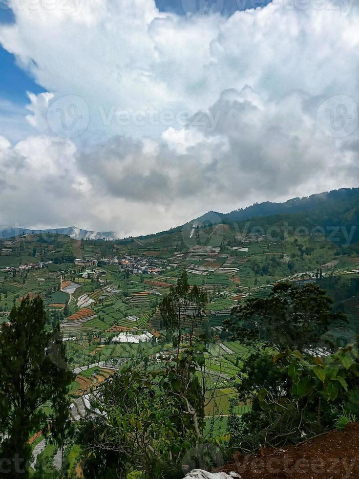 the village in the middle of the potato fields seen from the top of the hill in the Dieng plateau area photo