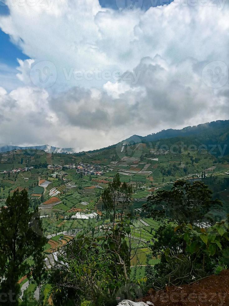 el pueblo en medio de los campos de papa visto desde la cima de la colina en el área de la meseta de dieng foto