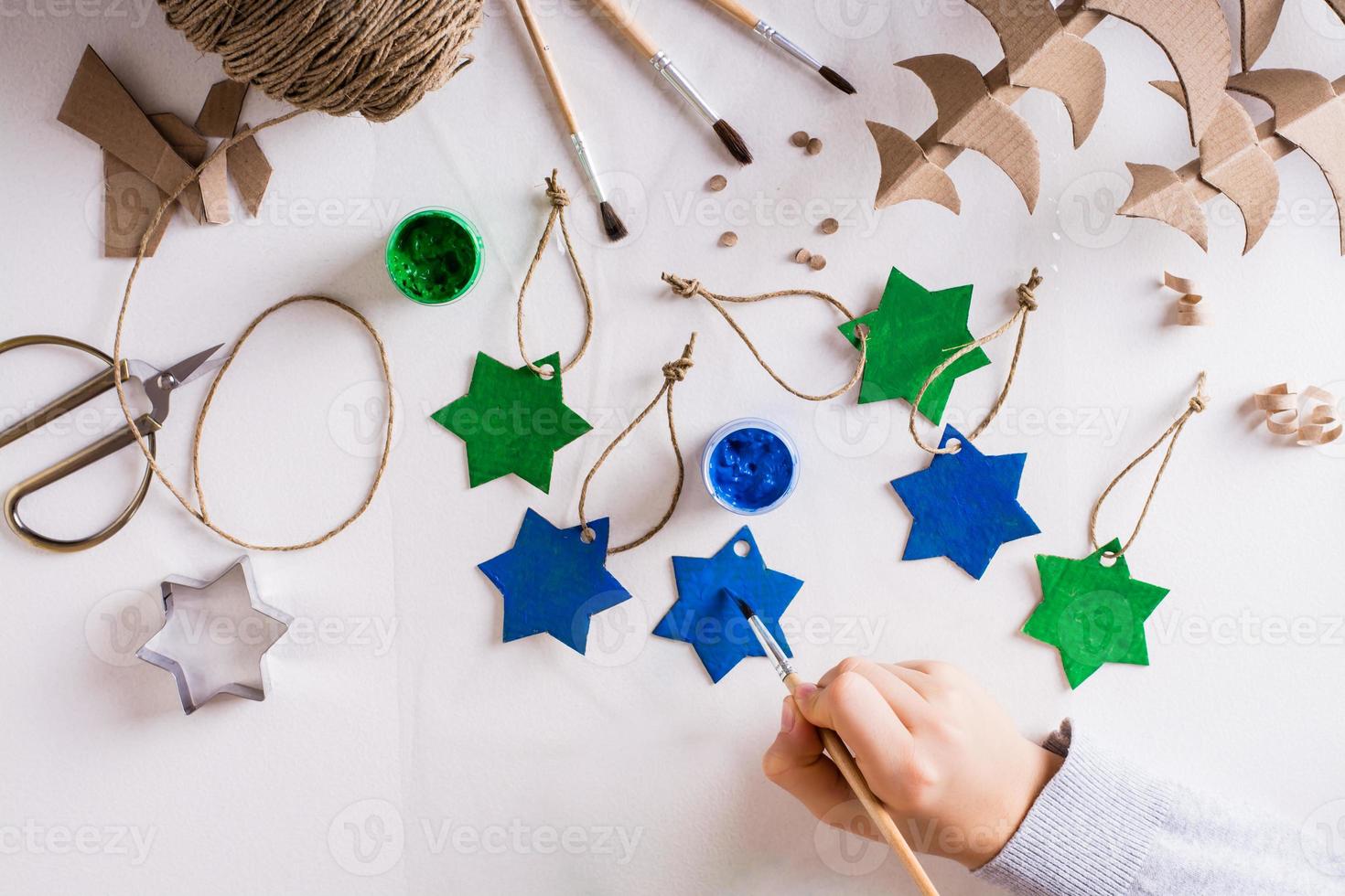 A girl paints a gouache star out of cardboard for DIY handmade ...