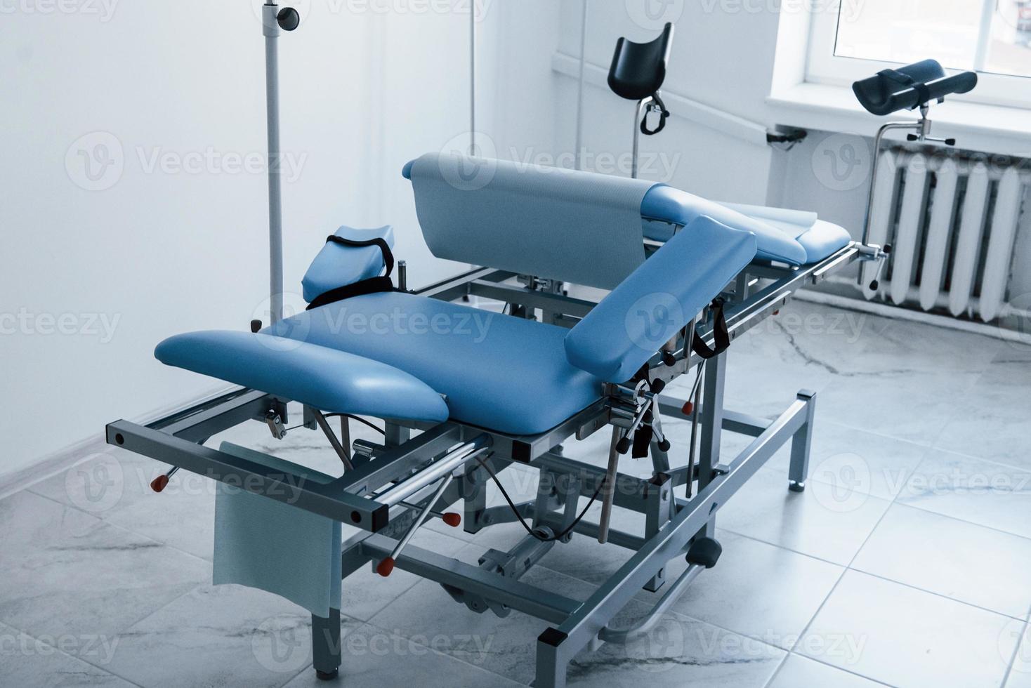 Blue colored obstetric bed indoors in the clinic cabinet at daytime photo