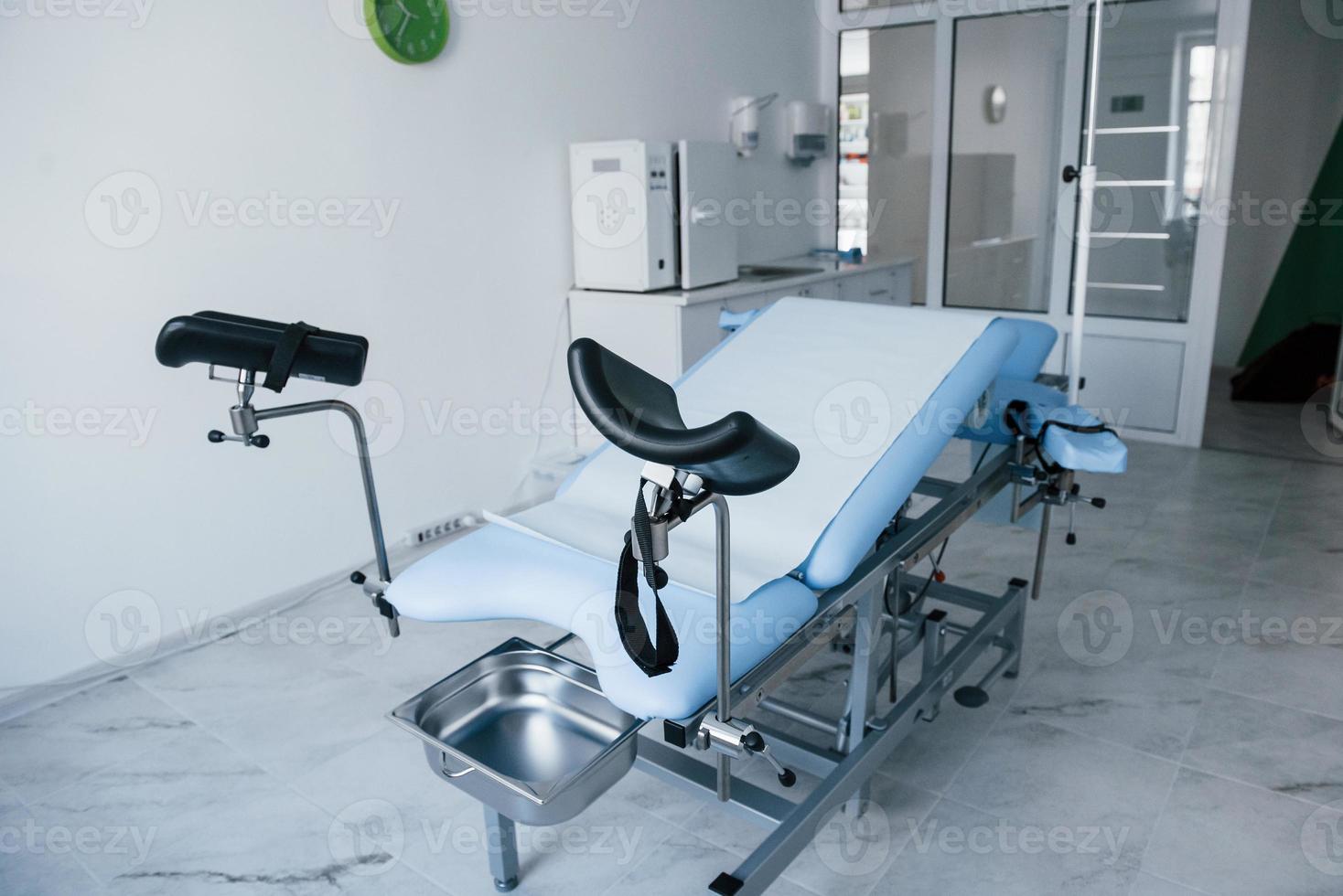 Blue colored obstetric bed indoors in the clinic cabinet at daytime photo