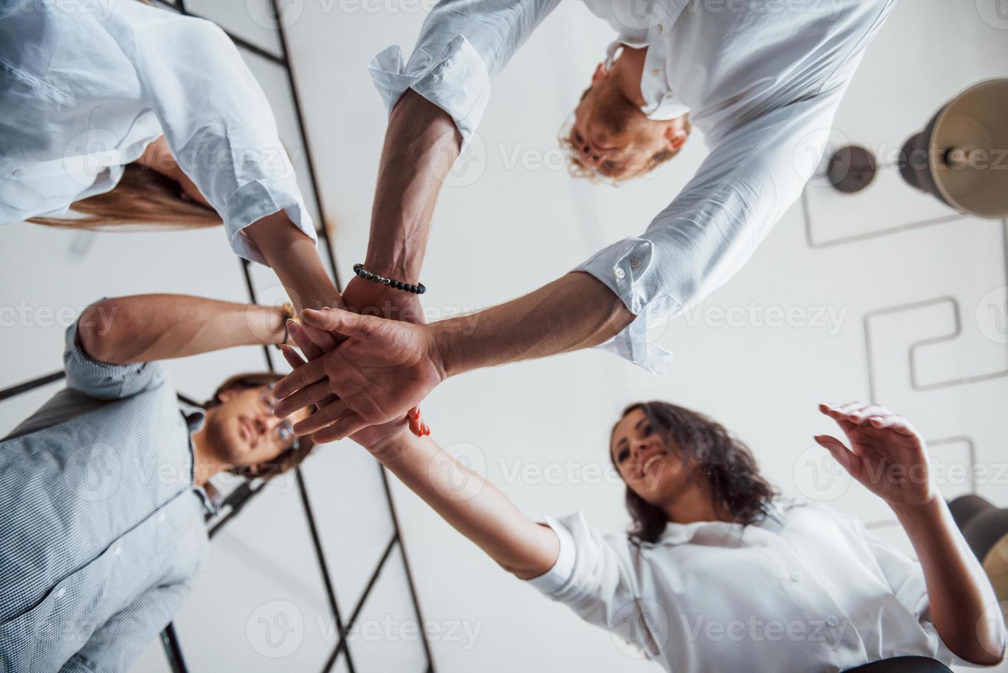 View from below. Successful business people putting their hands together photo