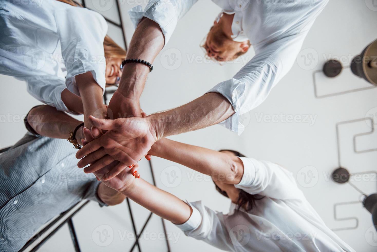 View from below. Successful business people putting their hands together photo